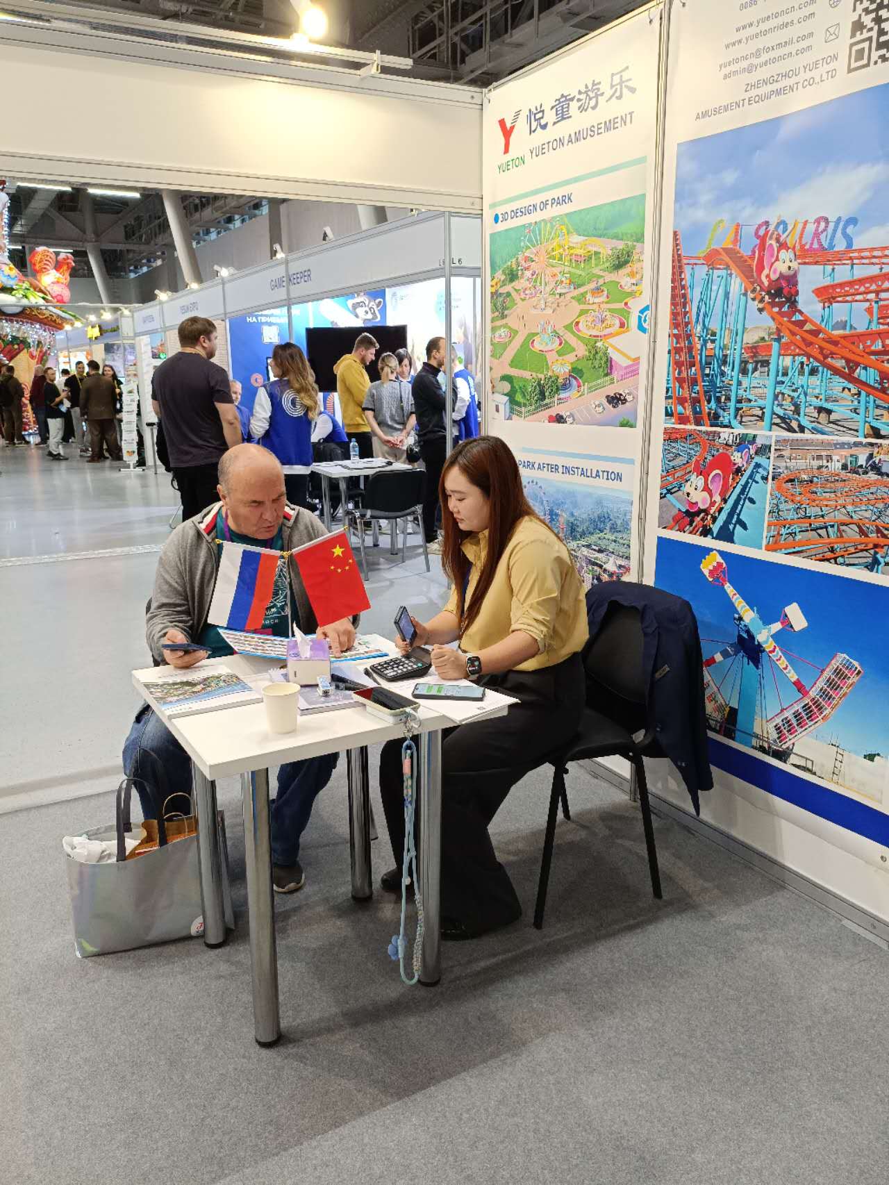Yueton representative reviewing ride drawings with a Russian park operator at RAAPA Autumn 2026